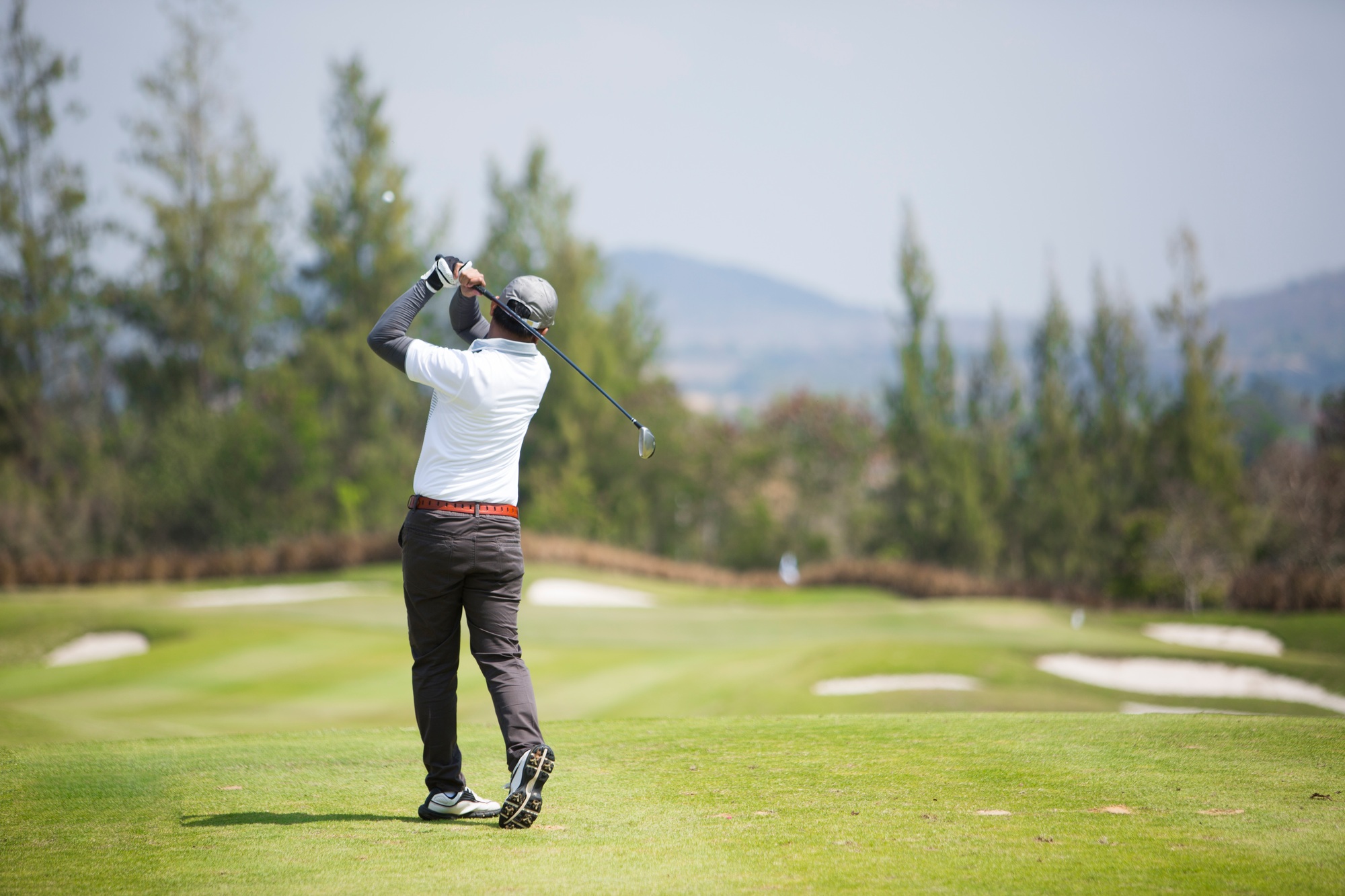 Golfers hit sweeping golf course in the summer